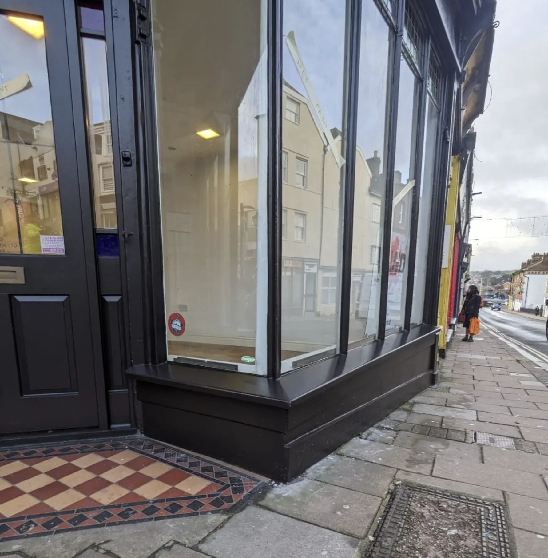 Freshly painted shop doorframe and large exterior window frames with clean, modern commercial finishes