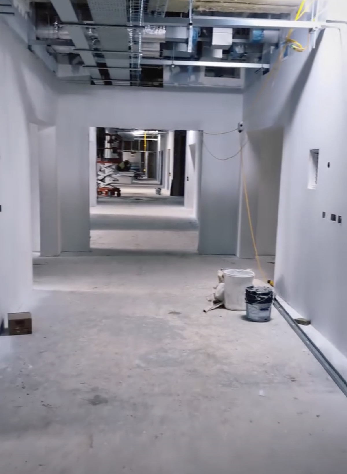 Industrial hallway mid-way through painting and decorating with surfaces prepped and partially coated