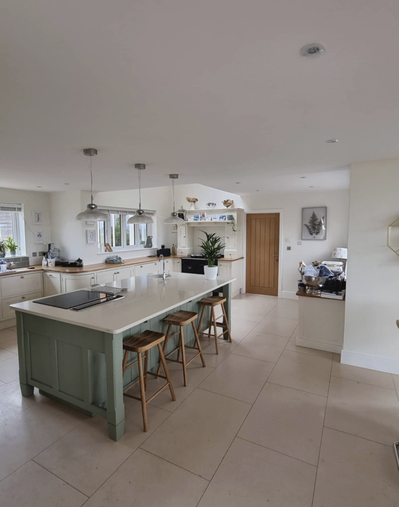 Corner view of a newly decorated modern kitchen with central island and fresh white and blue paintwork